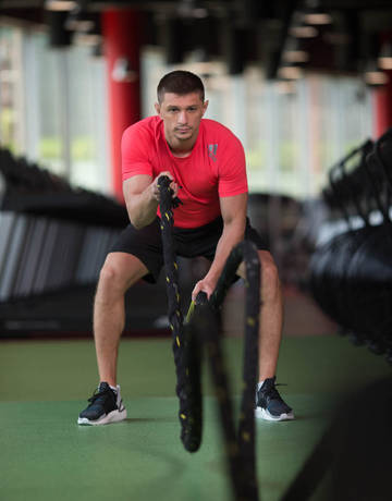 Athlete performing battle rope exercise Athlete performing battle rope exercise
