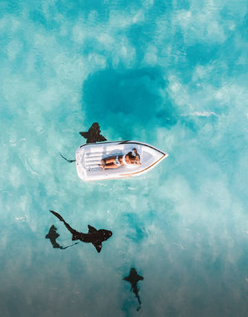 Man laying on a floating bed in the sea