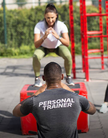 personal trainer coaching on squat exercise