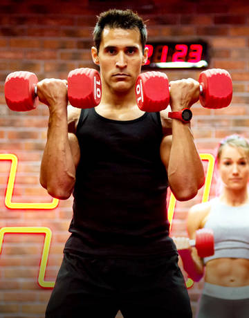 Man lifting dumbbells in a group Xfit class